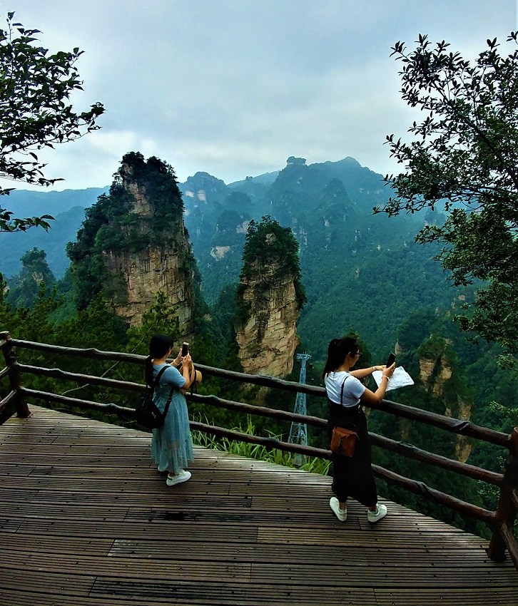 دو خانم در حال عکس برداری از کوه های ژانگجیاجیه